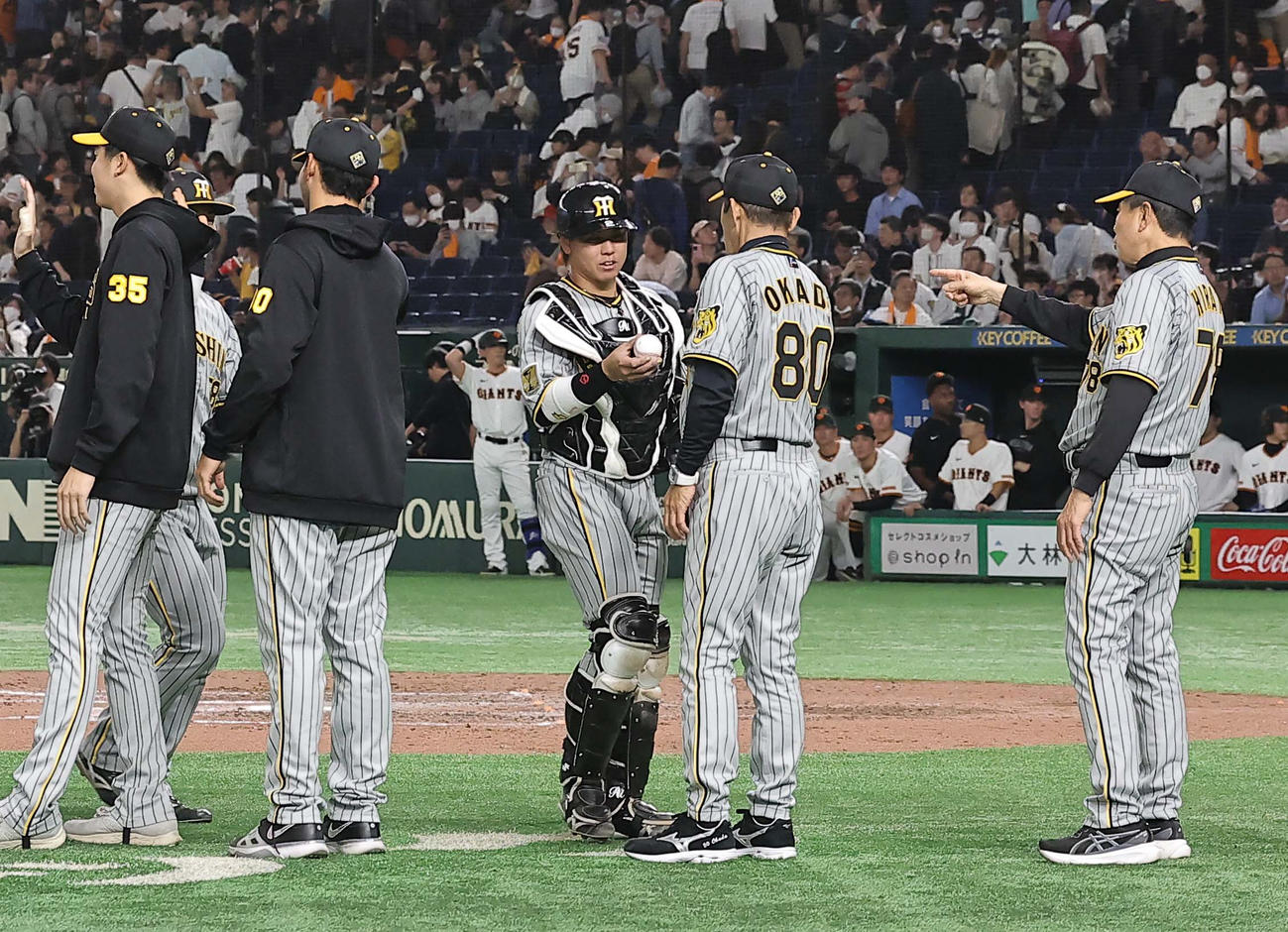 3月31日、巨人対阪神　梅野（中央左）は岡田監督に勝利球を手渡す