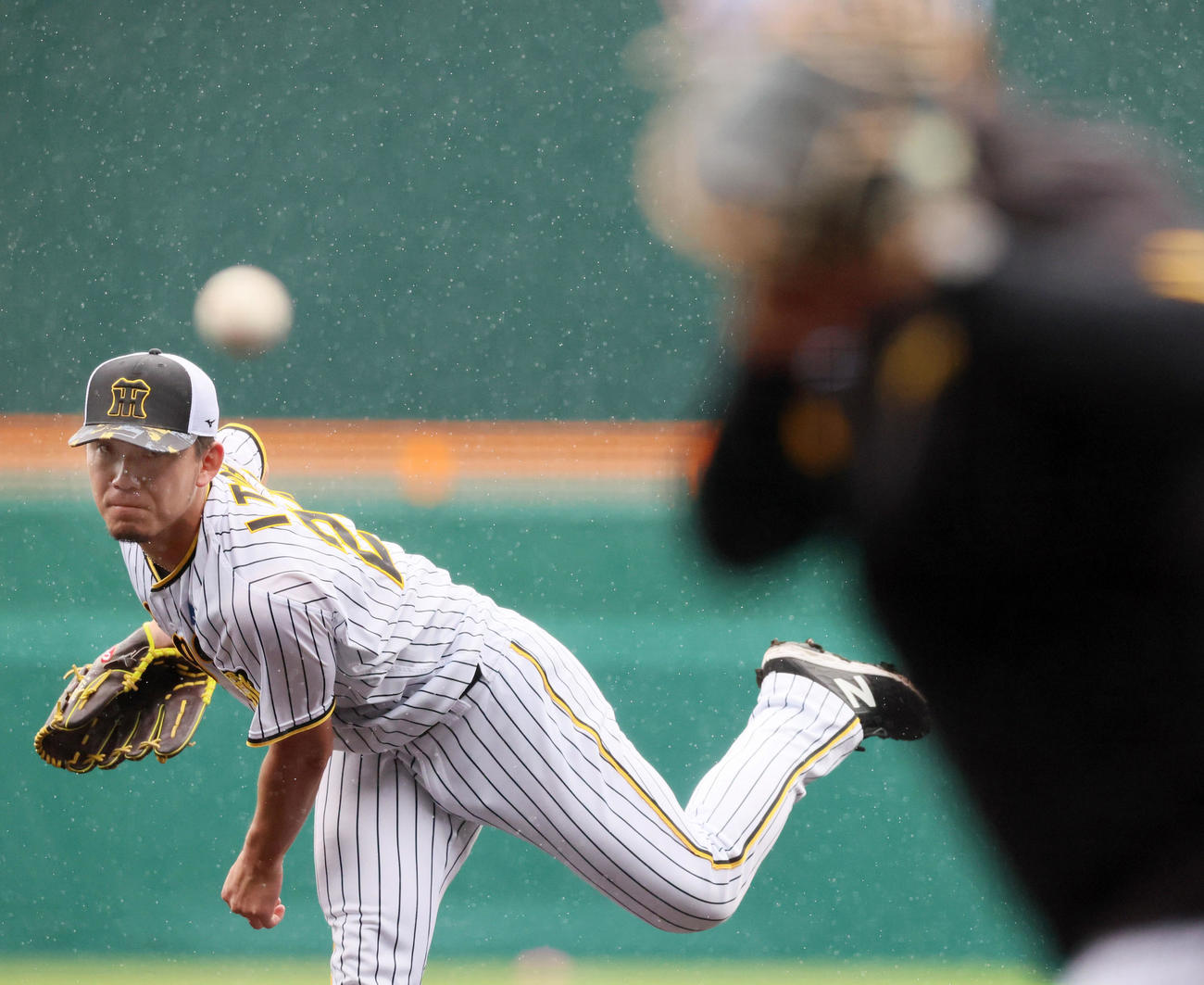 雨の降るマウンドから投球練習する伊藤将（撮影・加藤哉）