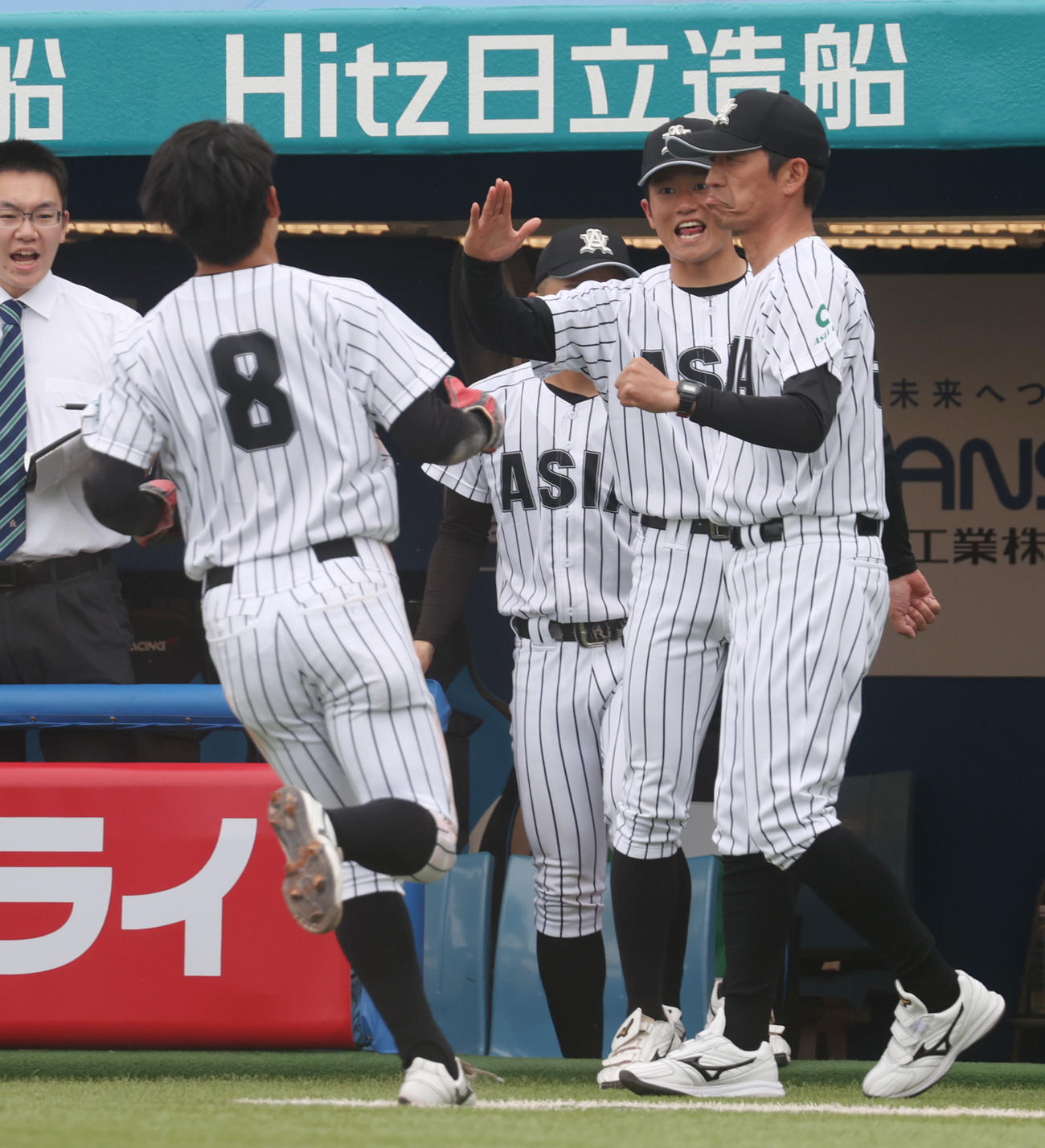 亜大対日大　3回裏亜大2死二塁、西川の左前適時打で二塁走者杉山が生還し正村監督（右端）が出迎える（撮影・柴田隆二）