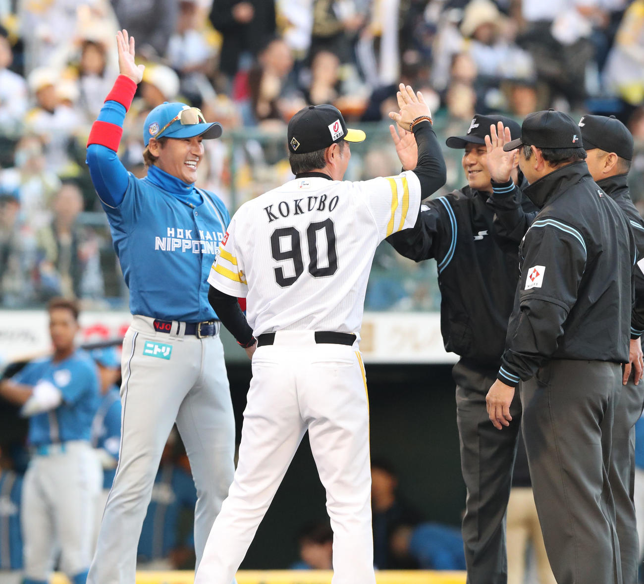 ソフトバンク対日本ハム　メンバー表を交換するときにハイタッチをかわす新庄監督と小久保監督（撮影・梅根麻紀）