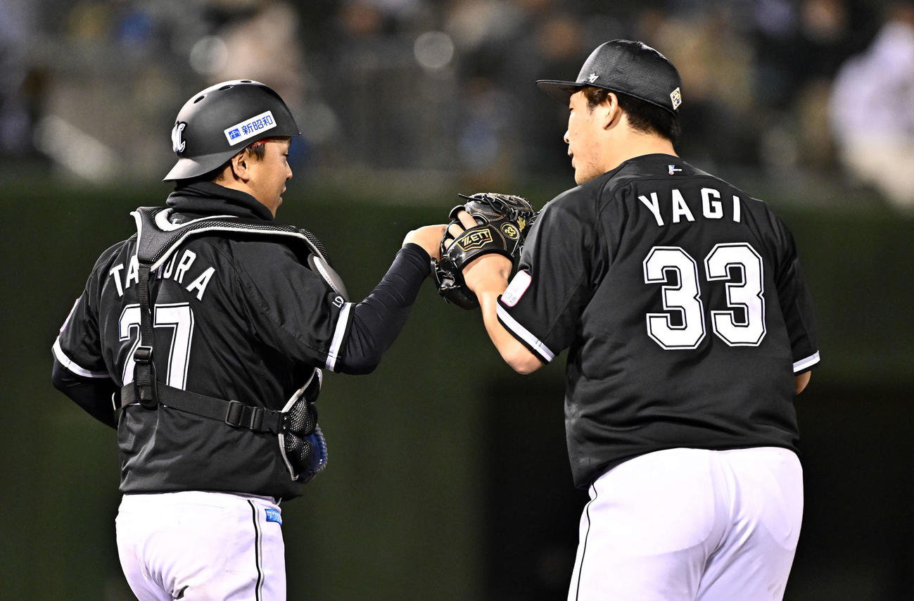 西武対ロッテ　9回裏、ロッテ3番手登板し試合を締めた八木（右）は田村とタッチをかわす（撮影・滝沢徹郎）