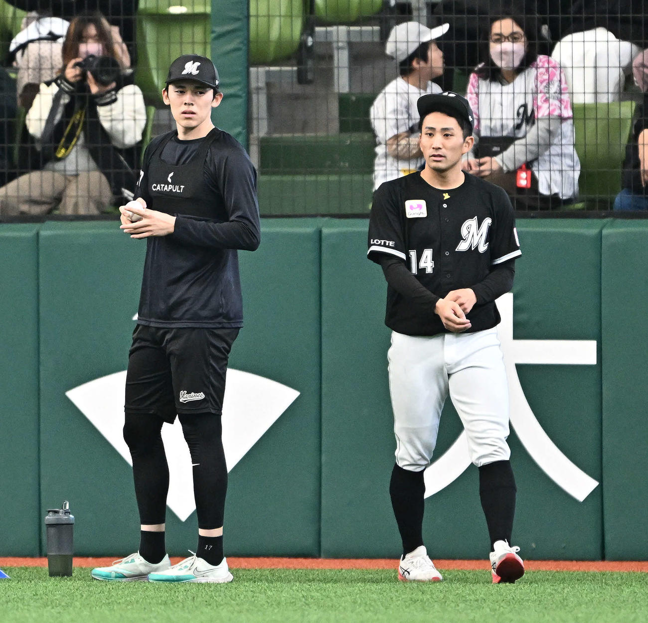 西武対ロッテ　完全試合を達成してちょうど２年がたち、ボールを拾いフォークの握りをするロッテ佐々木。右は小島（撮影・滝沢徹郎）