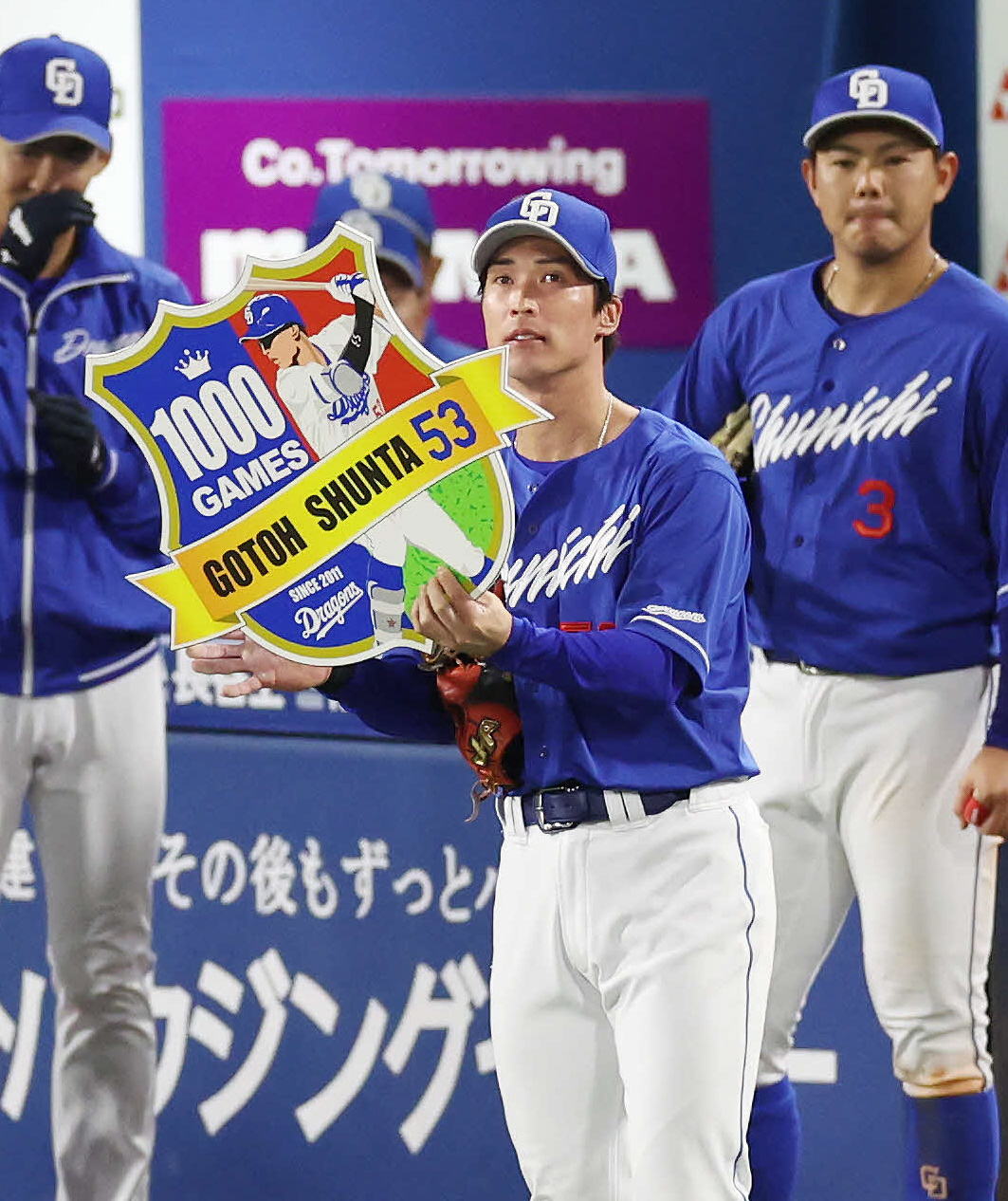 DeNA対中日　1000試合出場を達成し、チームから拍手を受けながら記念ボードを掲げる中日後藤（中央）（撮影・宮地輝）