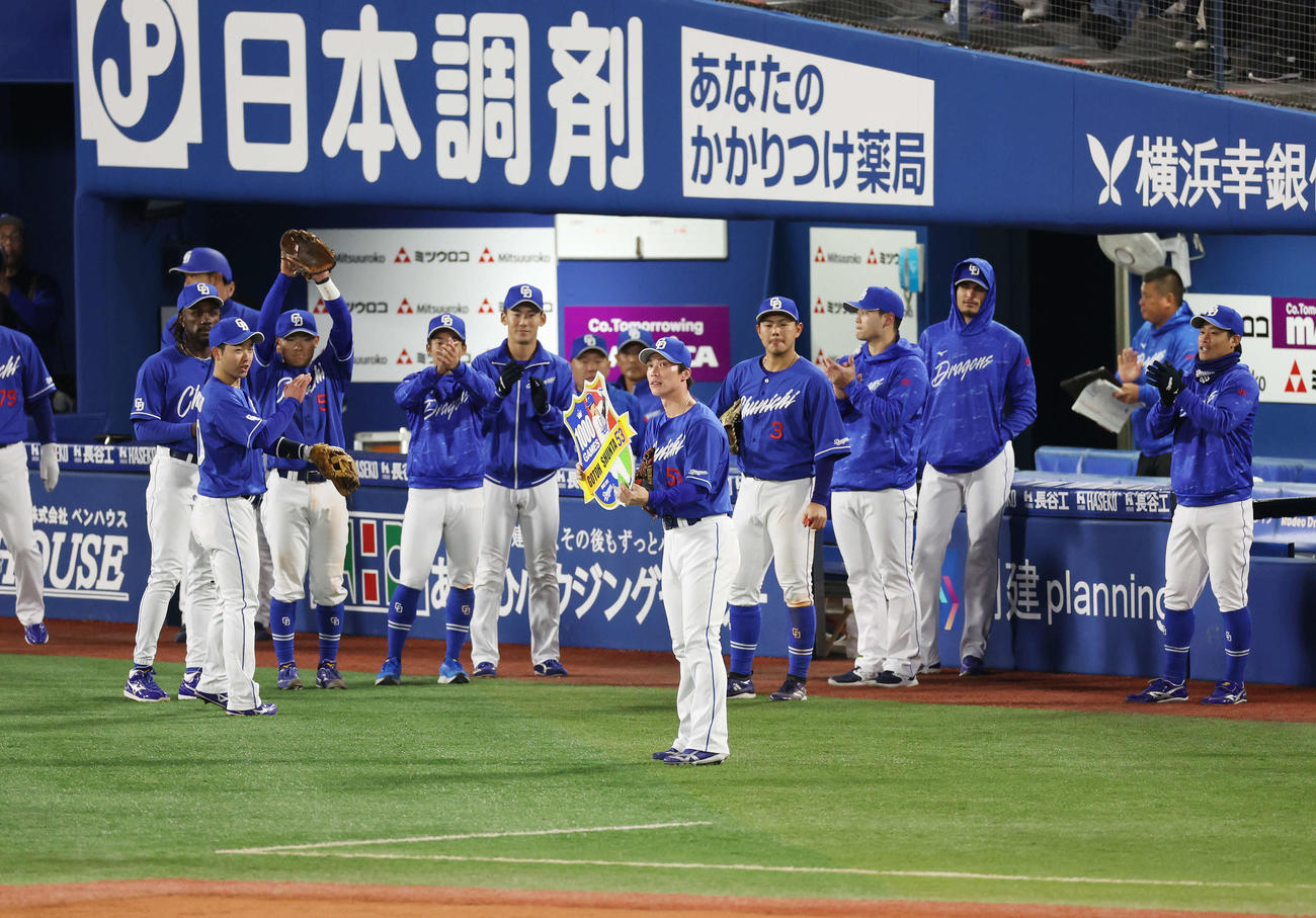 DeNA対中日　1000試合出場を達成し、チームから拍手を受けながら記念ボードを掲げる中日後藤（中央）（撮影・宮地輝）