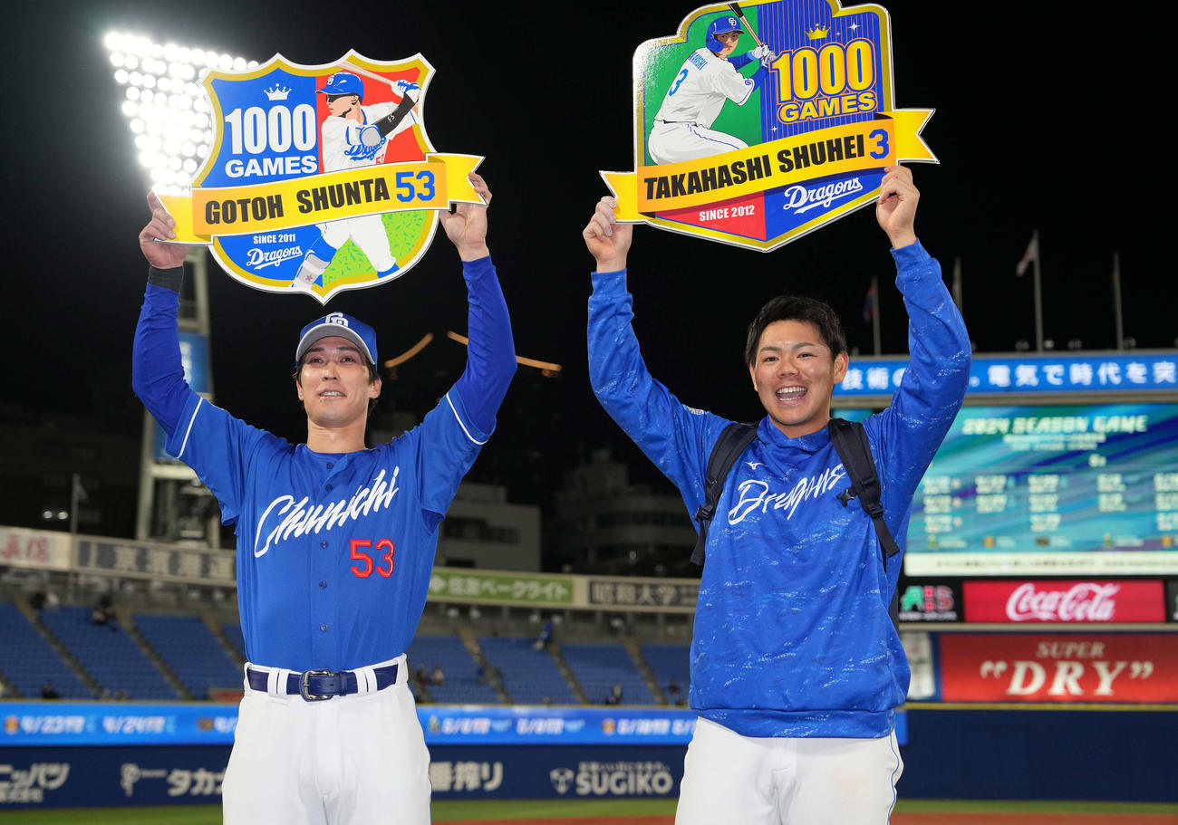 DeNA対中日　同日通算1000試合出場を達成した中日後藤（左）と高橋周は笑顔で記念ボードを掲げる（撮影・井上学）