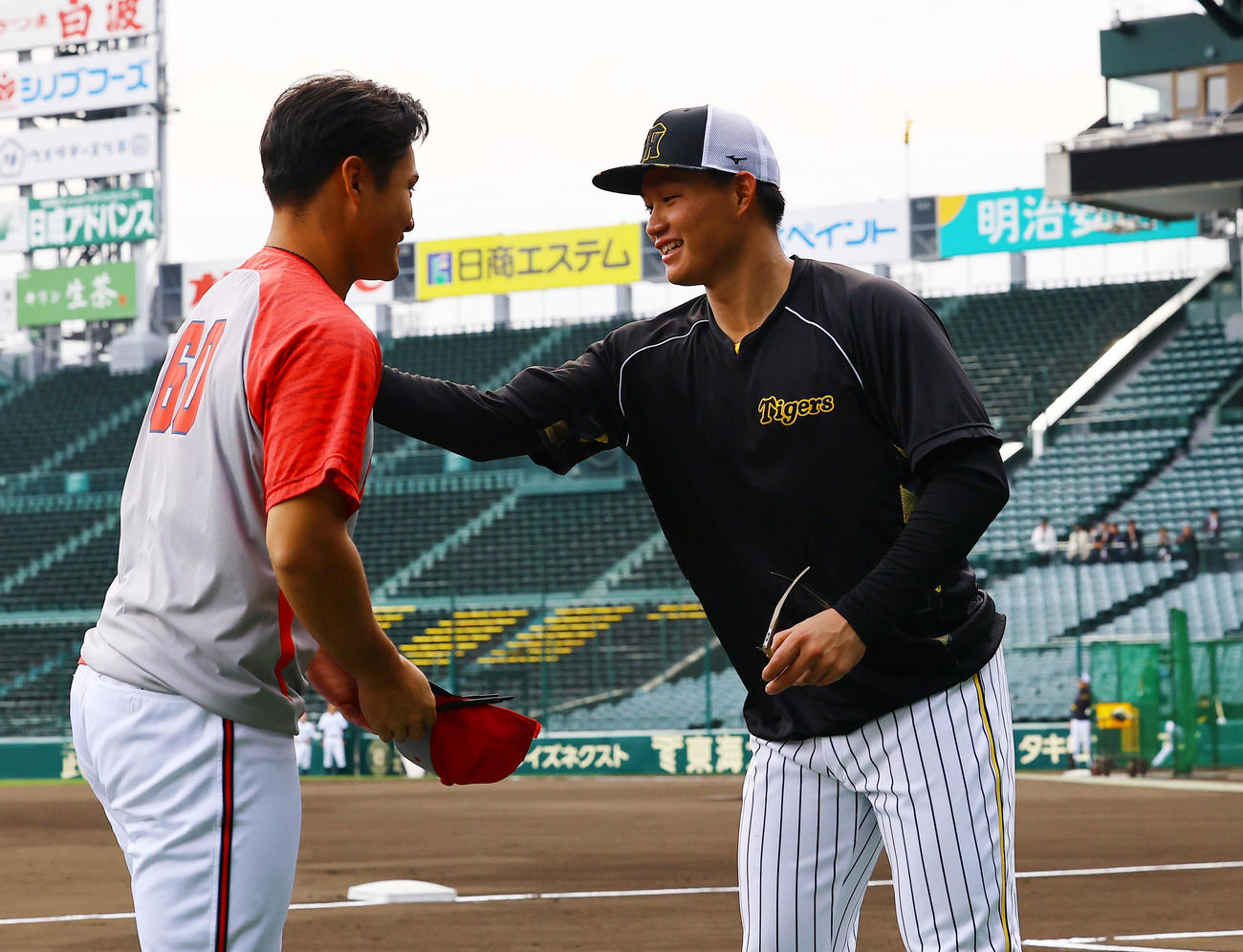 広島田村（左）の肩をたたく阪神森下（撮影・藤尾明華）
