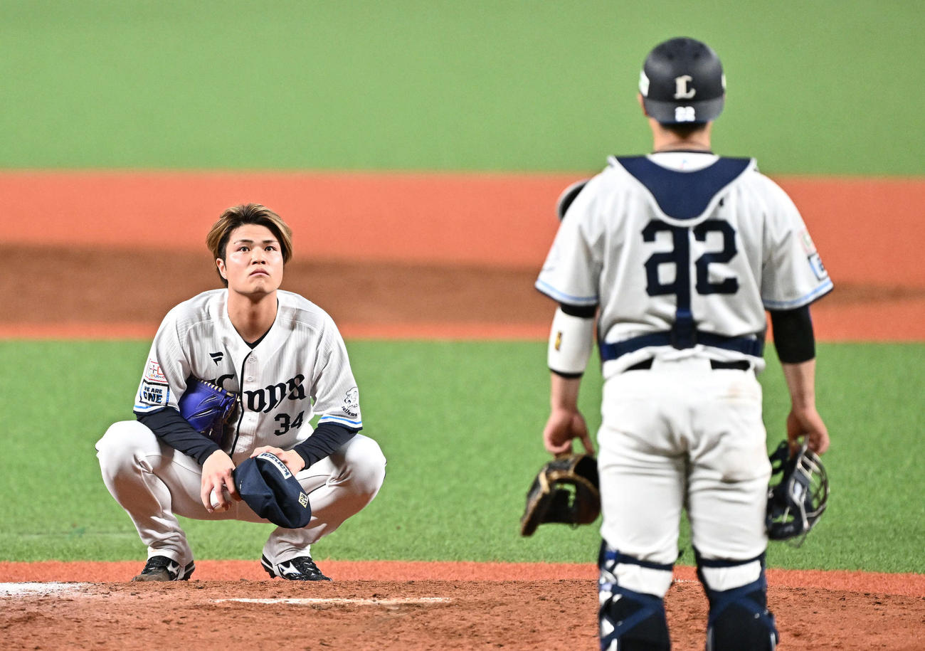 西対ソフトバンク　8回表ソフトバンク2死一、二塁、二塁走者川村の本塁セーフの判定がリクエストとなりリプレー検証の映像を見る甲斐野（左）。捕手古賀（撮影・滝沢徹郎）