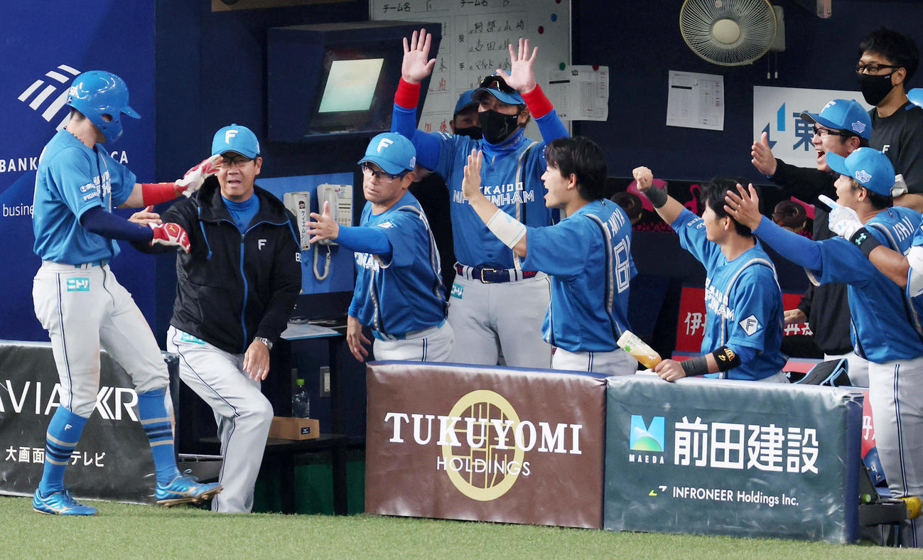 オリックス対日本ハム　6回表日本ハム1死三塁、郡司の三ゴロで生還した五十幡（左端）をバンザイで迎える新庄監督（中央）ら日本ハムの選手たち（撮影・前田充）