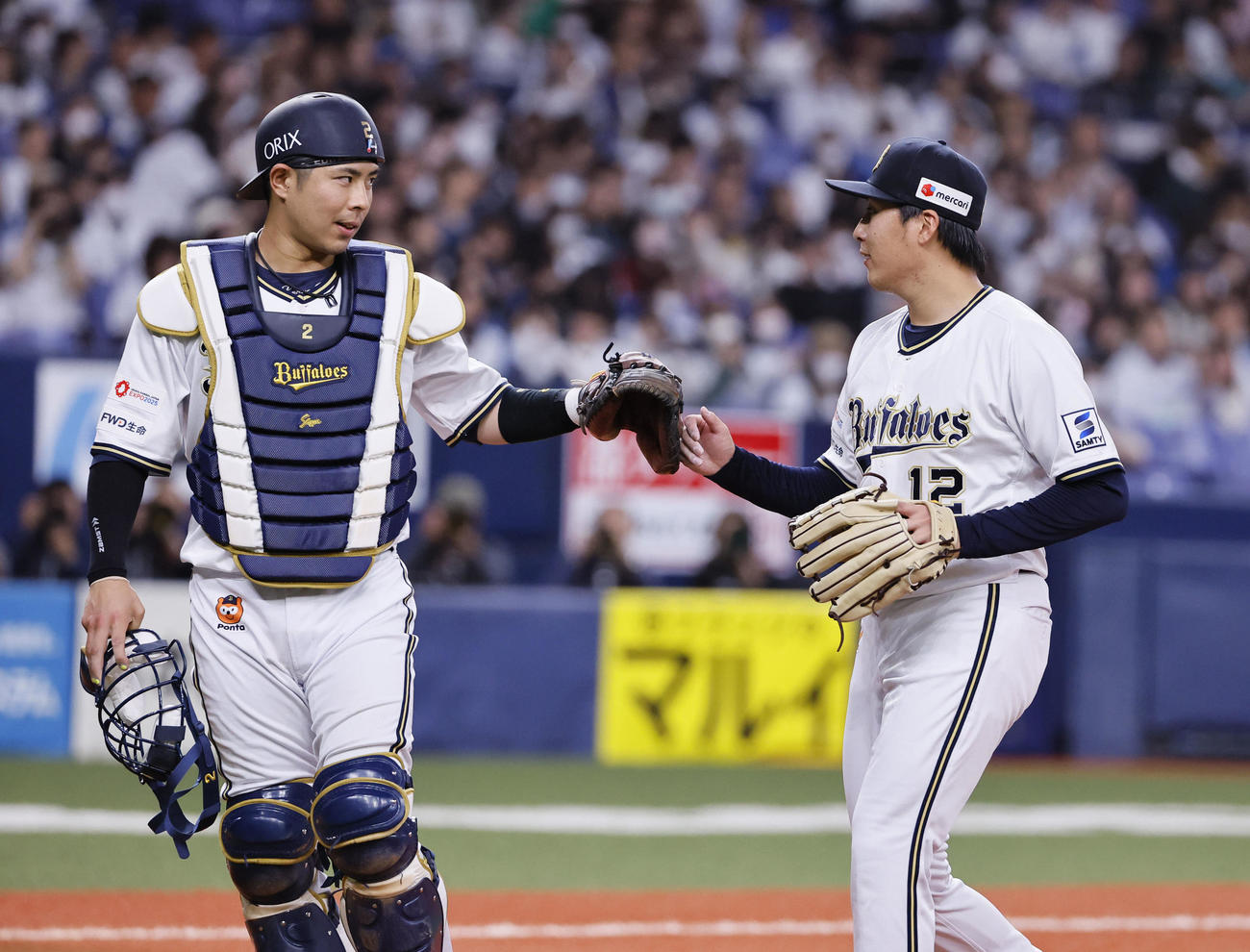オリックス対日本ハム　3回を終えタッチを交わすオリックス若月（左）と東（撮影・藤尾明華）