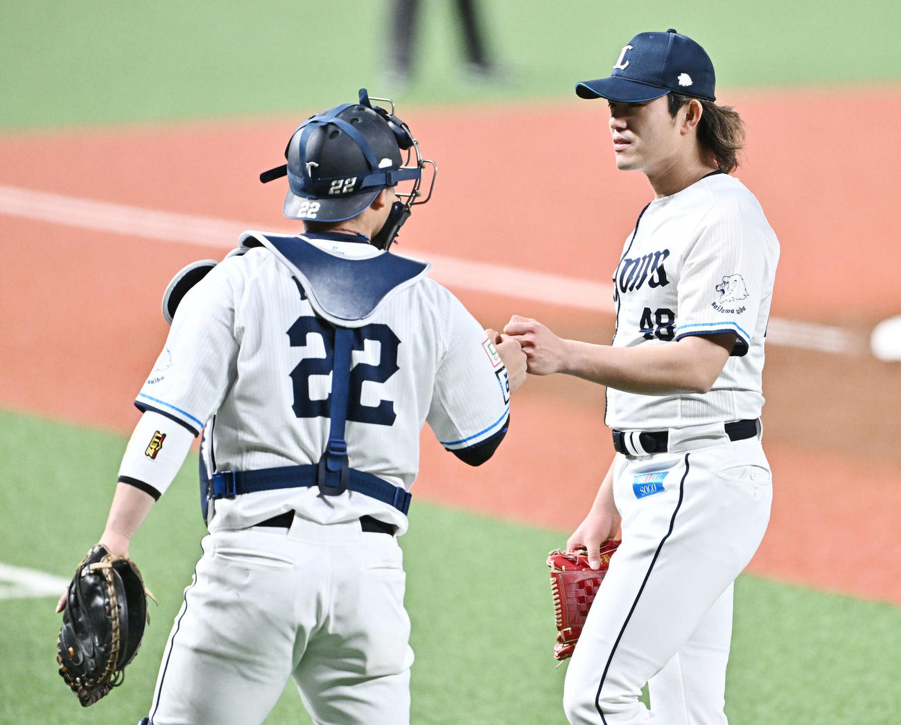 西武対ソフトバンク　1回表を投げ終えた西武先発の今井（右）は捕手古賀とタッチをかわす（撮影・滝沢徹郎）