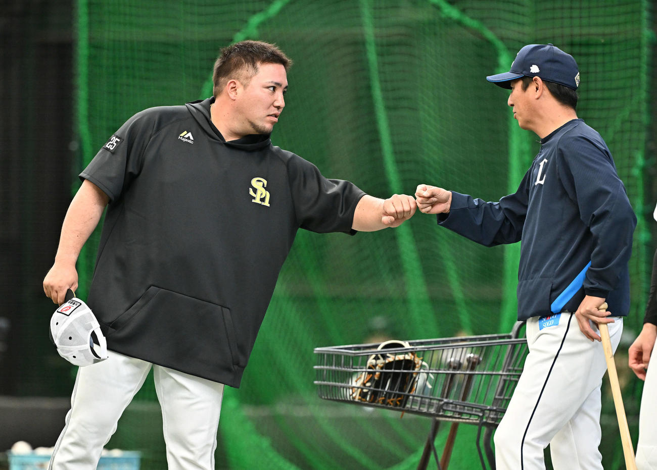 西武対ソフトバンク　試合前練習でソフトバンク山川（左）は西武平石ヘッドコーチとグータッチする（撮影・滝沢徹郎）