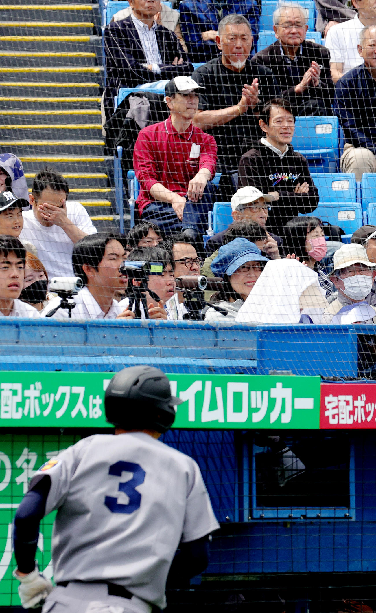 慶大対東大　3回表慶大1死二、三塁、横地広太の中前適時打で生還した清原正吾（手前）に拍手を送る父和博氏（上段）（撮影・野上伸悟）