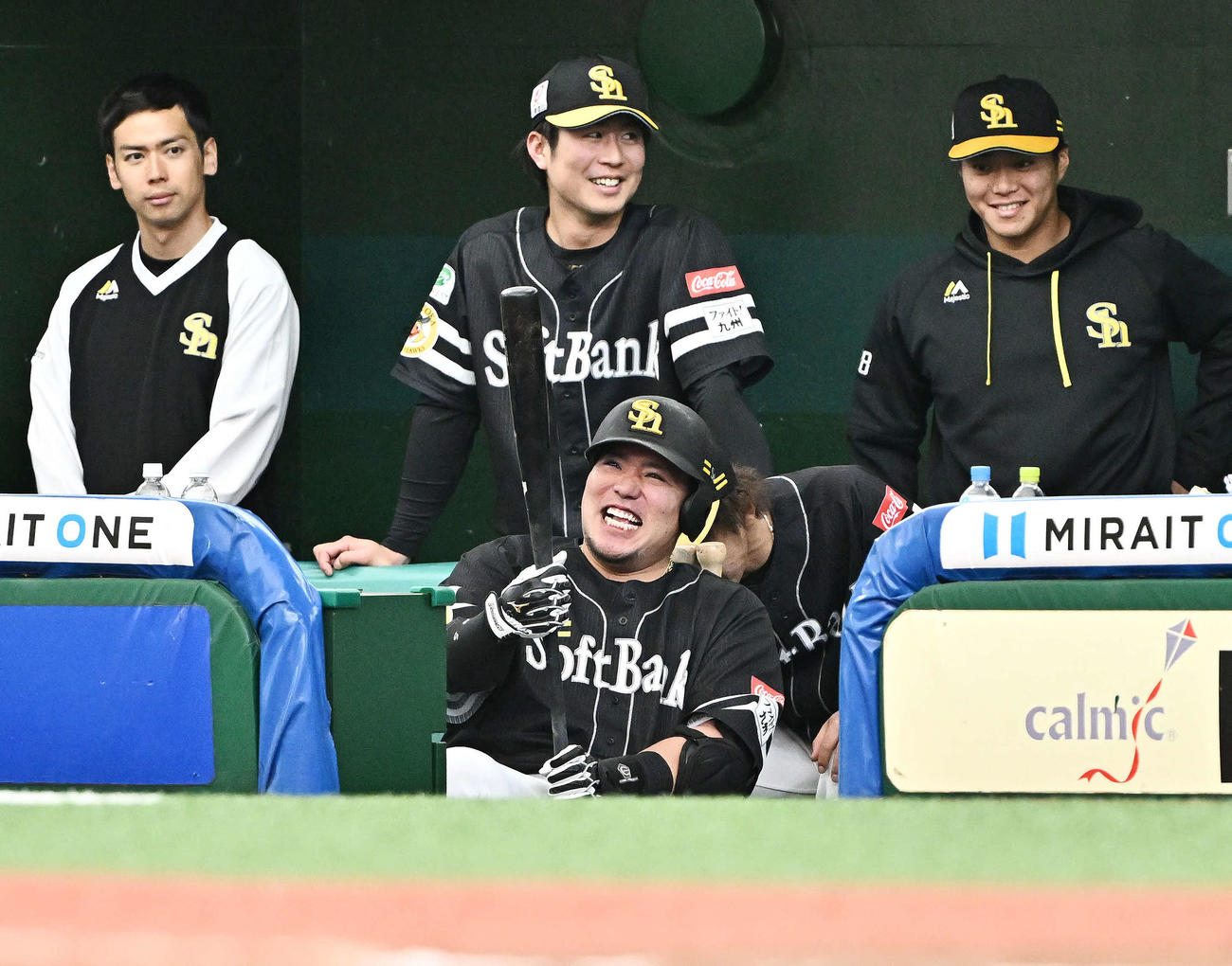 西武対ソフトバンク　6回表ソフトバンク1死満塁、満塁本塁打を放った山川（手前）はベンチに戻りバットを手に笑顔を見せる（撮影・滝沢徹郎）