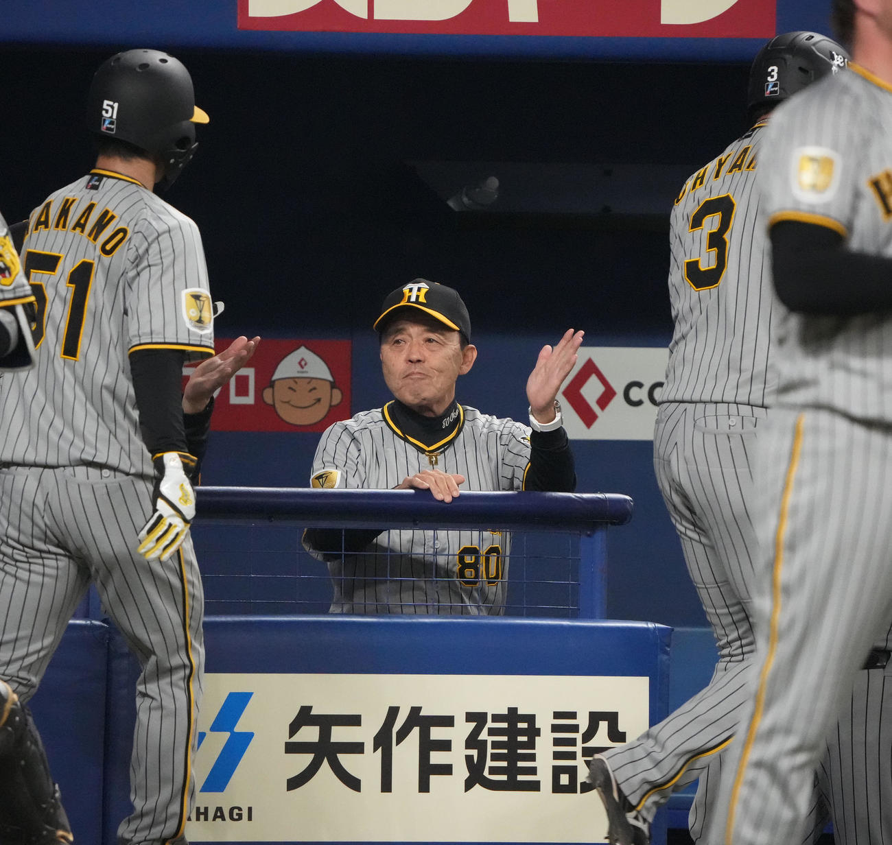 中日対阪神　1回表阪神2死一、二塁、佐藤輝の右中間2点適時二塁打で生還した大山、中野らを迎える岡田監督（中央）（撮影・森本幸一）