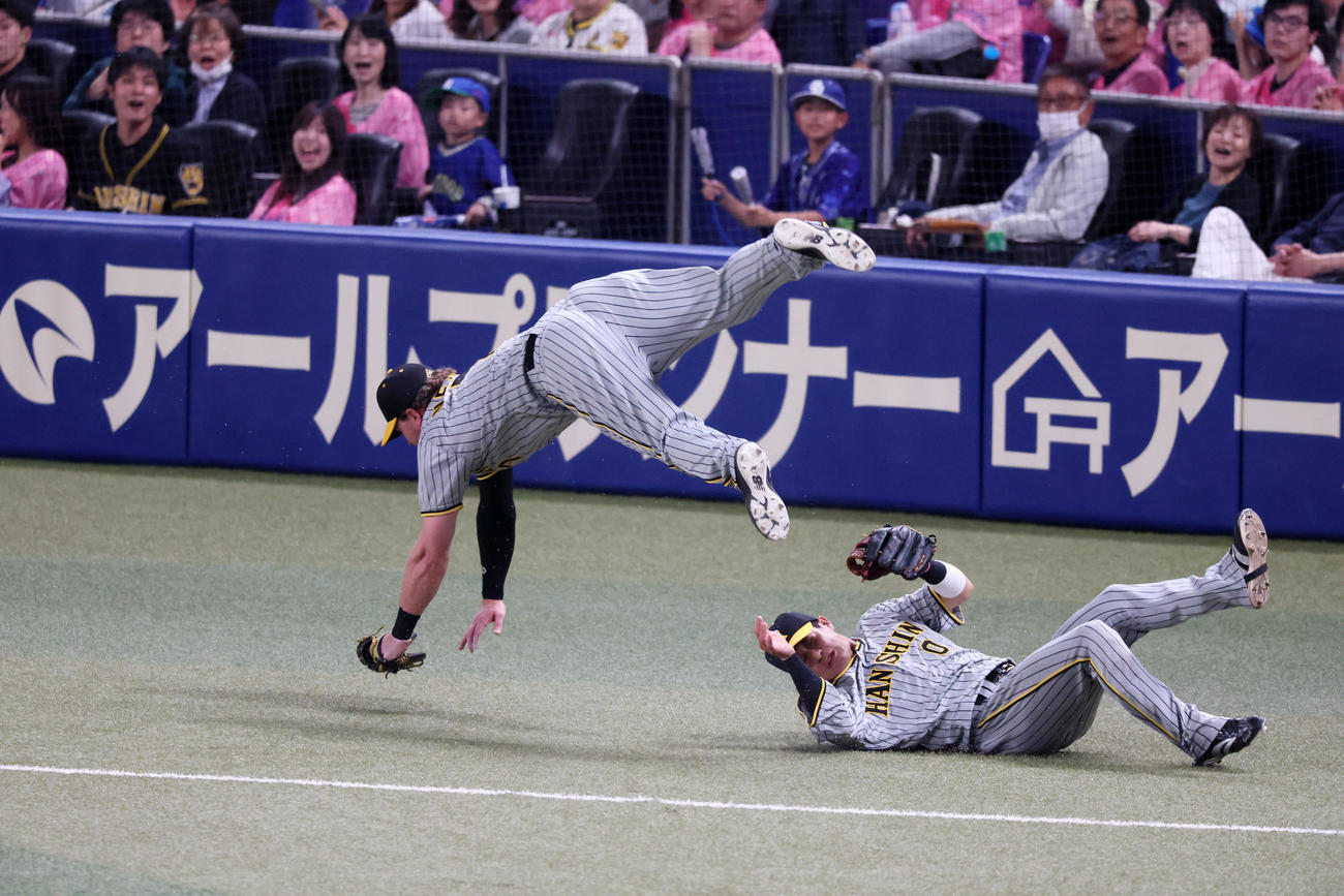 中日対阪神　i回裏中日無死、ノイジーは三好の打球を追った木浪（右）との接触を避けるためうまく身体をかわしてジャンプする（撮影・加藤哉）