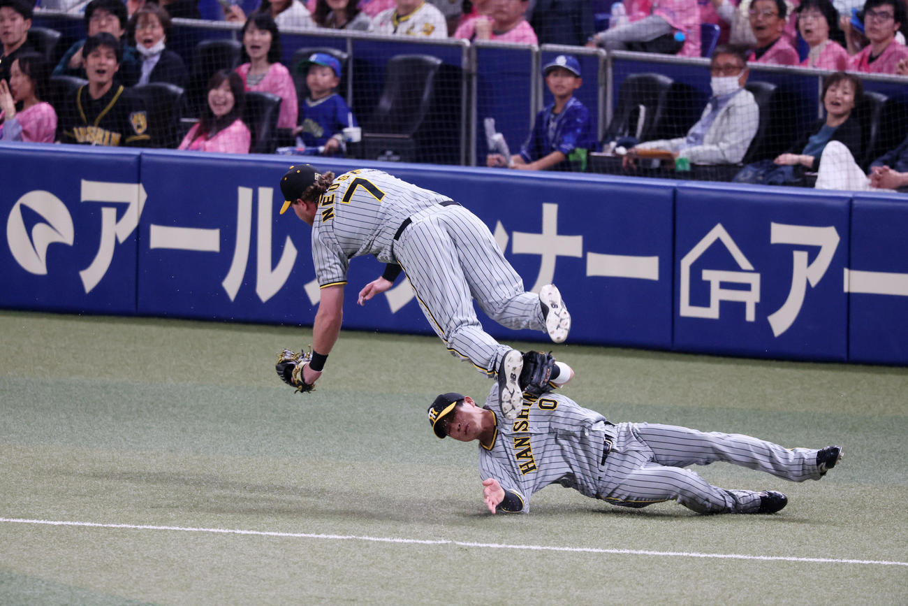 中日対阪神　i回裏中日無死、ノイジーは三好の打球を追った木浪（右）との接触を避けるためうまく身体をかわしてジャンプする（撮影・加藤哉）