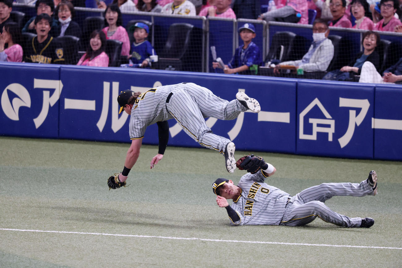 中日対阪神　i回裏中日無死、ノイジーは三好の打球を追った木浪（右）との接触を避けるためうまく身体をかわしてジャンプする（撮影・加藤哉）
