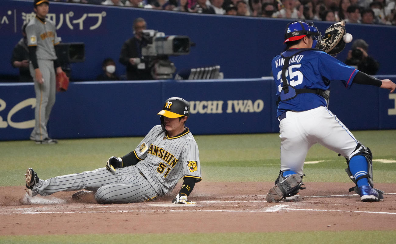 中日対阪神　3回表阪神2死一、二塁、梅野の中前適時打で生還する中野（左）。捕手木下（撮影・森本幸一）