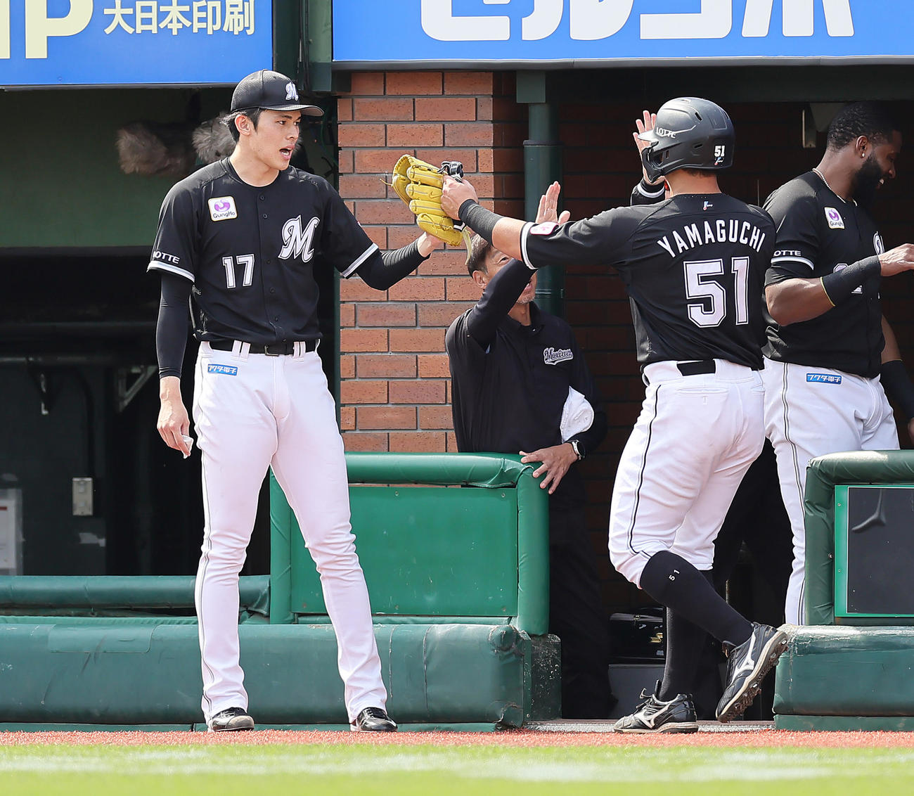 楽天対ロッテ　3回表ロッテ2死三塁、小川の左前適時打で生還した山口（右）をタッチで迎える佐々木（撮影・足立雅史）