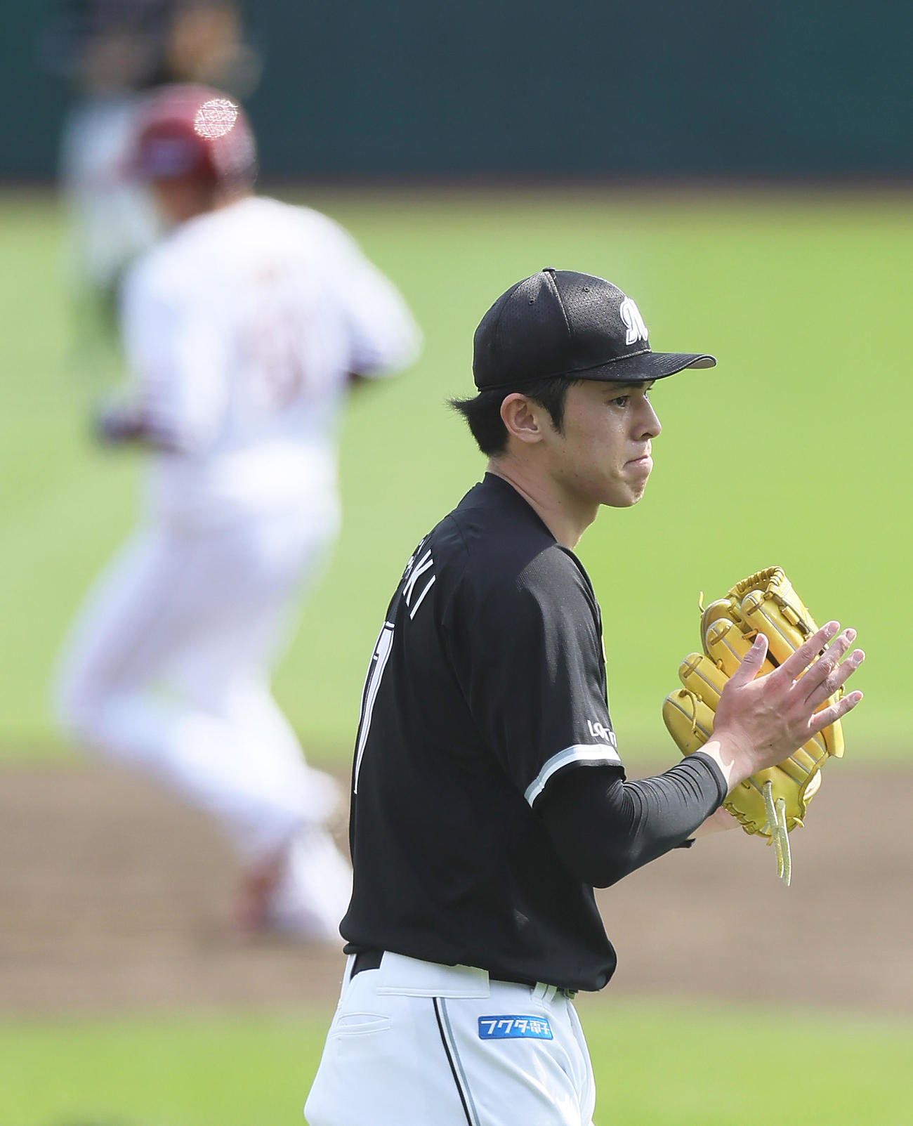 楽天対ロッテ　3回裏楽天2死一、二塁、浅村（後方）を遊ゴロに仕留めグラブをたたく佐々木（撮影・足立雅史）
