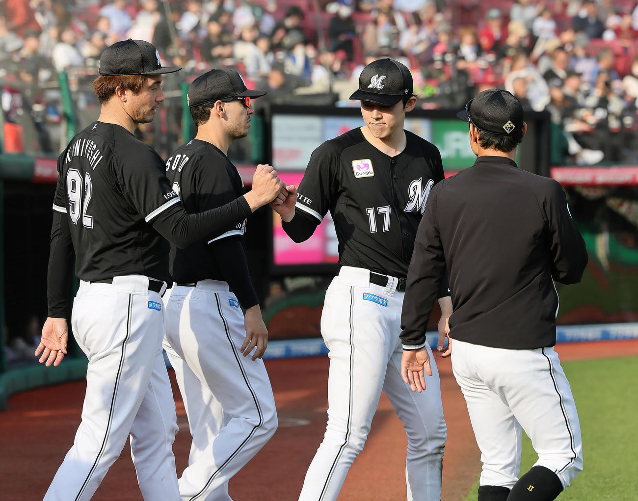 楽天対ロッテ　7回2失点で勝利を挙げタッチを交わすロッテ佐々木（中央右）（撮影・足立雅史）