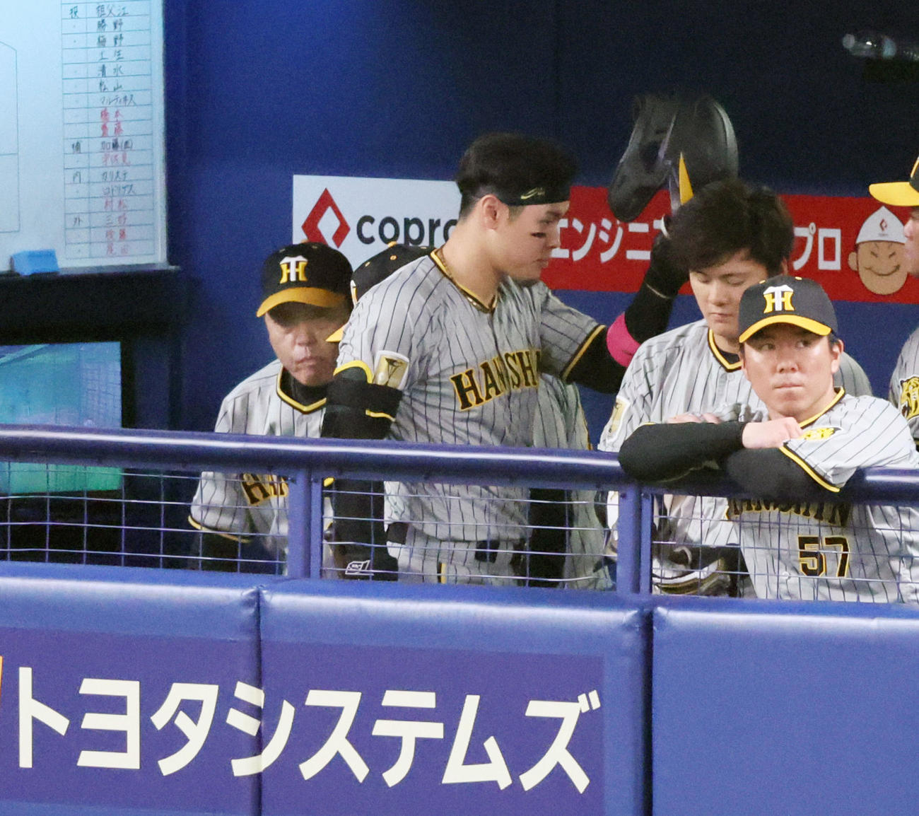 中日対阪神　6回表阪神1死、三振に倒れベンチへ引き揚げる佐藤輝。左は岡田監督（撮影・加藤哉）