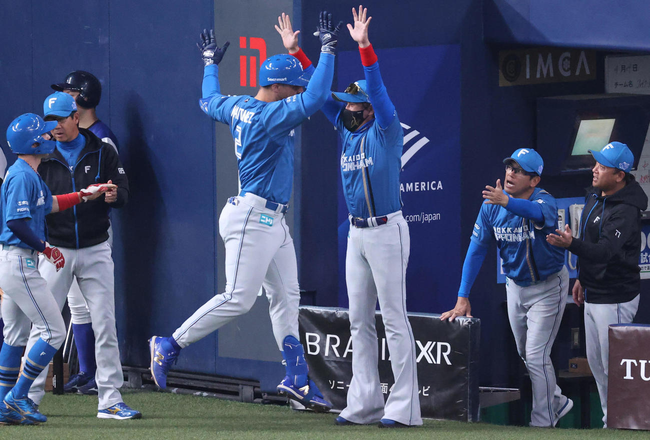 オリックス対日本ハム　1回表日本ハム1死一、二塁、先制の左越え3点本塁打を放ち、新庄監督（中央右）とタッチをかわすルティネス（撮影・上山淳一）