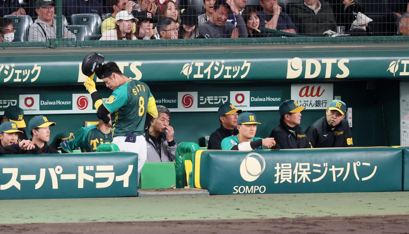 阪神対巨人　4回裏阪神無死一、二塁、佐藤輝は三振に倒れベンチへ引き揚げる。右端は岡田監督（撮影・加藤哉）