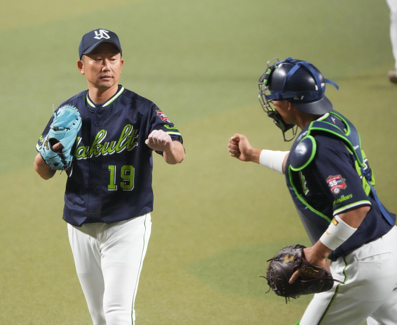 中日対ヤクルト　2回終了、中村とタッチを交わしベンチへ戻る石川（左）（撮影・森本幸一）