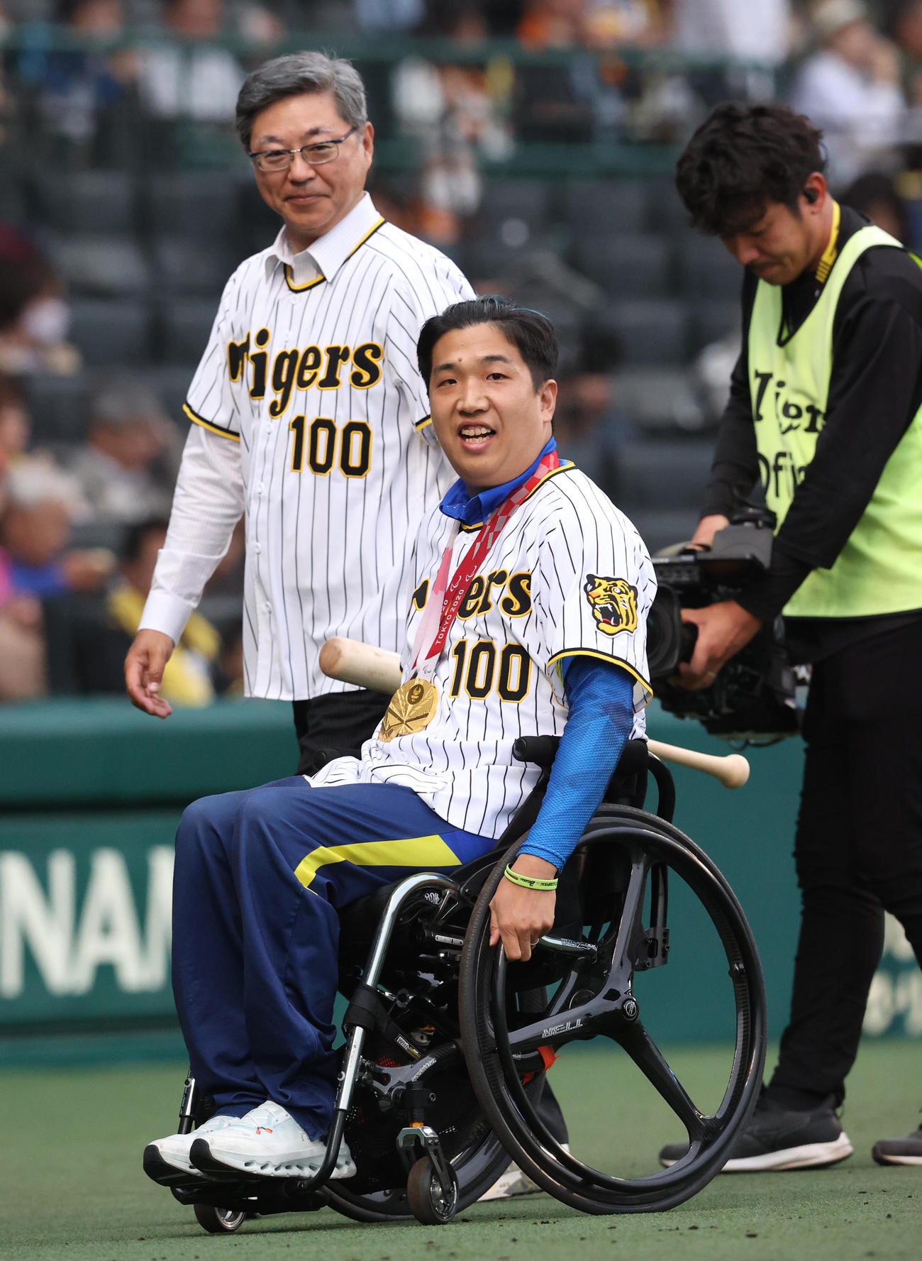 阪神対巨人　試合前、ファーストピッチセレモニーで投球を終えたパラリンピック金メダリストの佐藤友祈（手前）は笑顔を見せる（撮影・上山淳一）