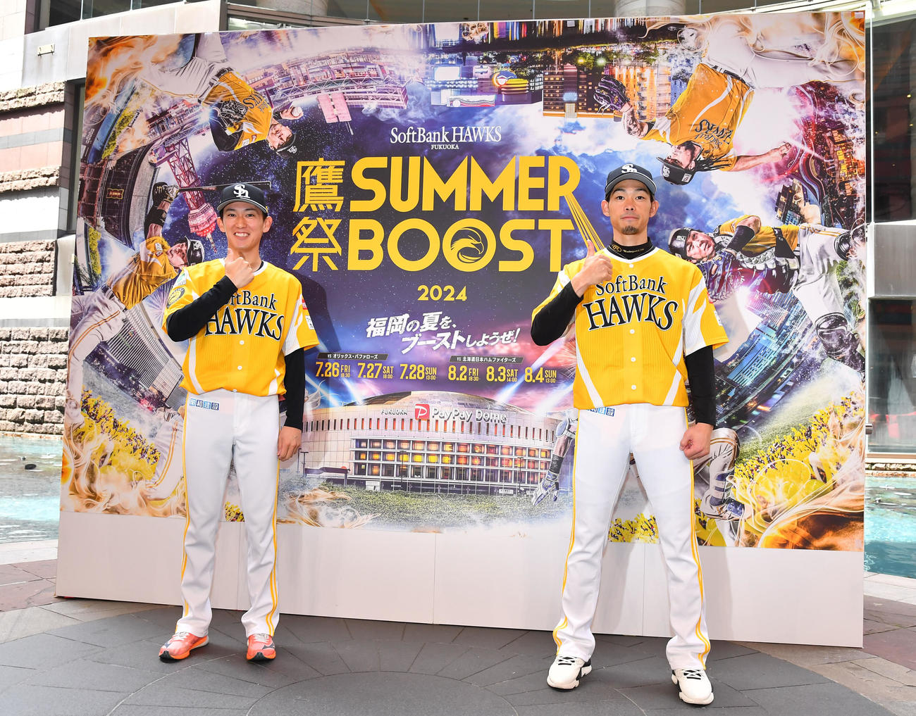 「鷹祭SUMMER BOOST」の発表会見で、期間中に着用される特別ユニホームを着てポーズを決める大津（左）と又吉（撮影・岩下翔太）