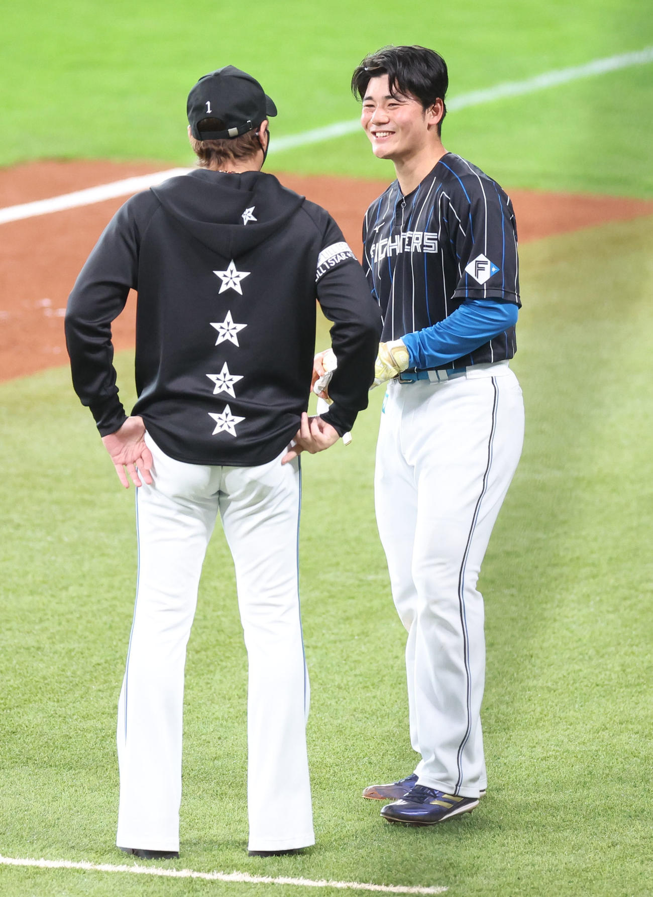 日本ハム対ロッテ　試合前、会話する日本ハム新庄監督（左手前）と清宮（撮影・佐藤翔太）