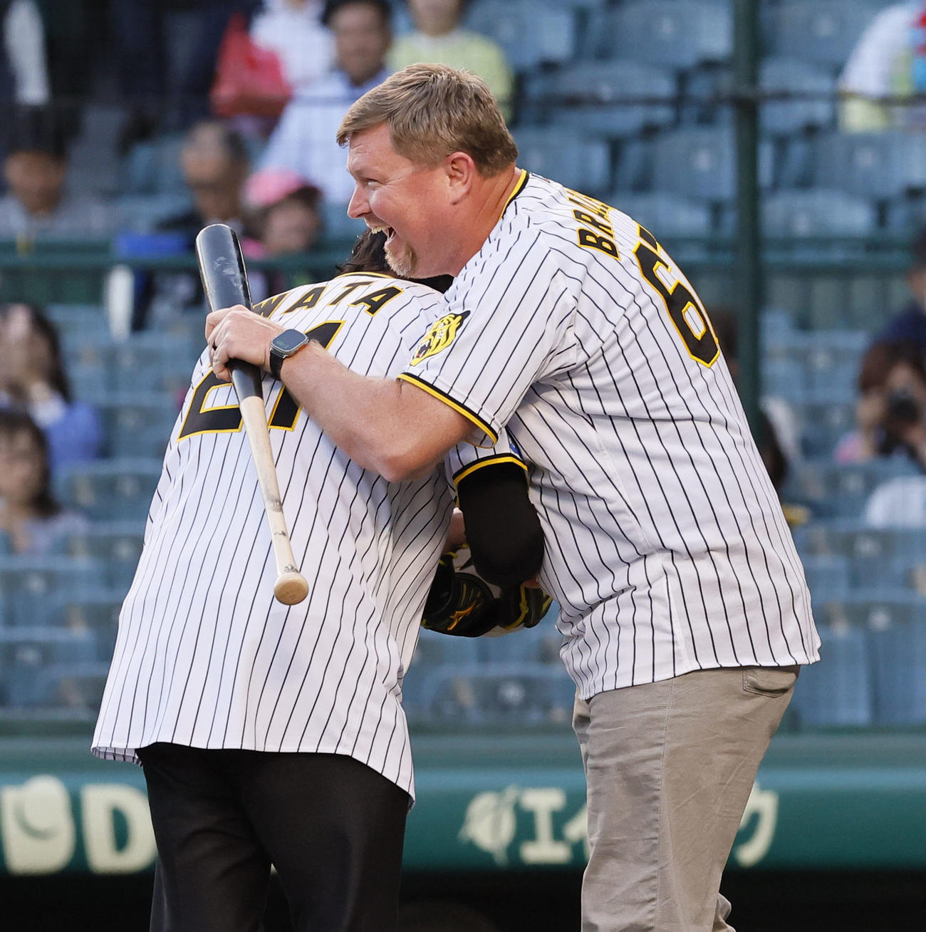 阪神対中日　ファーストピッチを終え、抱き合うブラゼル氏（右）と岩田稔氏（撮影・藤尾明華）