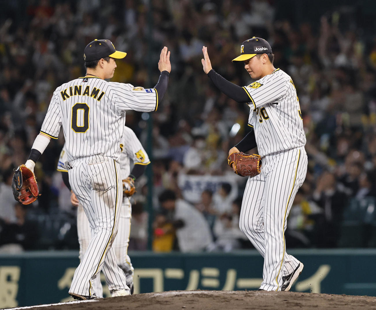 阪神対中日　中日に勝利し、木浪（左）とタッチを交わす阪神門別（撮影・藤尾明華）