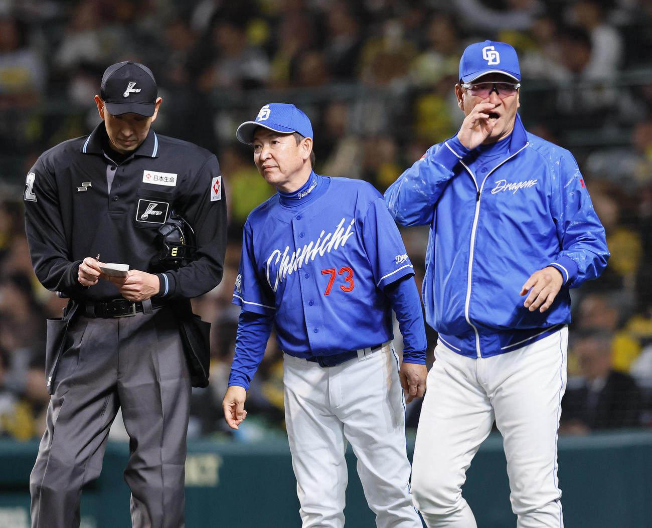 阪神対中日　7回、立浪監督（中央）から聞いた交代を選手に伝える中日片岡ヘッドコーチ（撮影・藤尾明華）