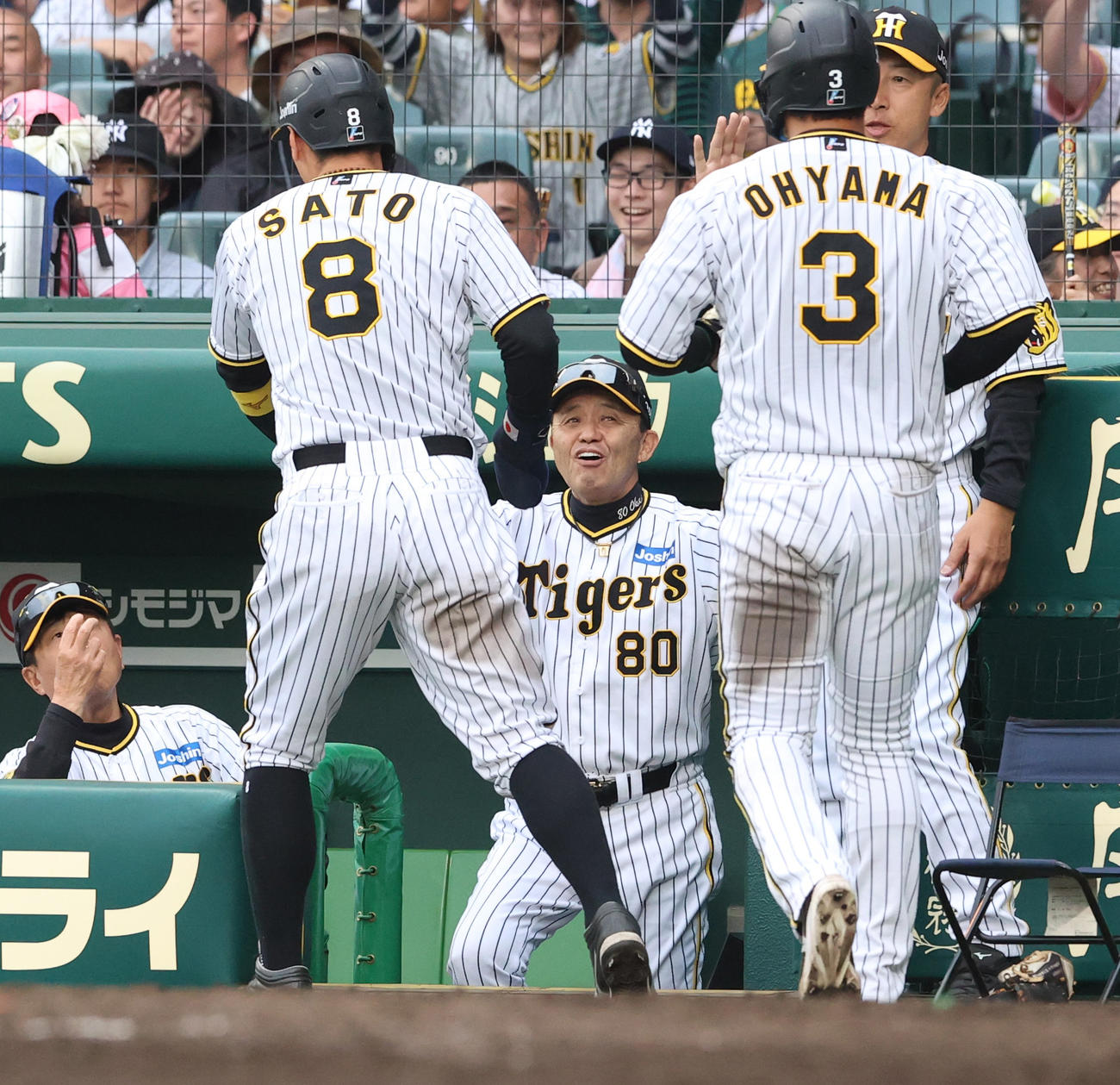 阪神対中日　7回裏阪神2死一、二塁、岡田監督（左から3人目）は前川の適時2点二塁打で生還した佐藤輝（手前左）と大山（手前右）を笑顔で迎える（撮影・上山淳一）
