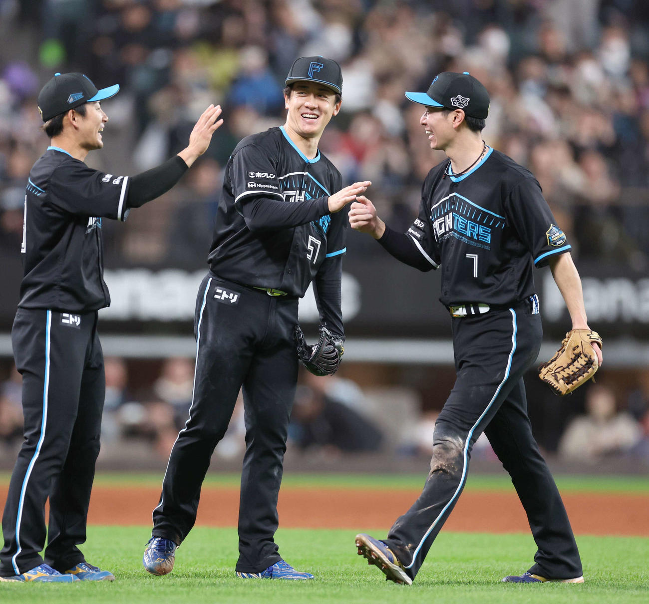 日本ハム対ロッテ　完封勝利した北山（中央）は松本剛（右）とタッチする（撮影・黒川智章）