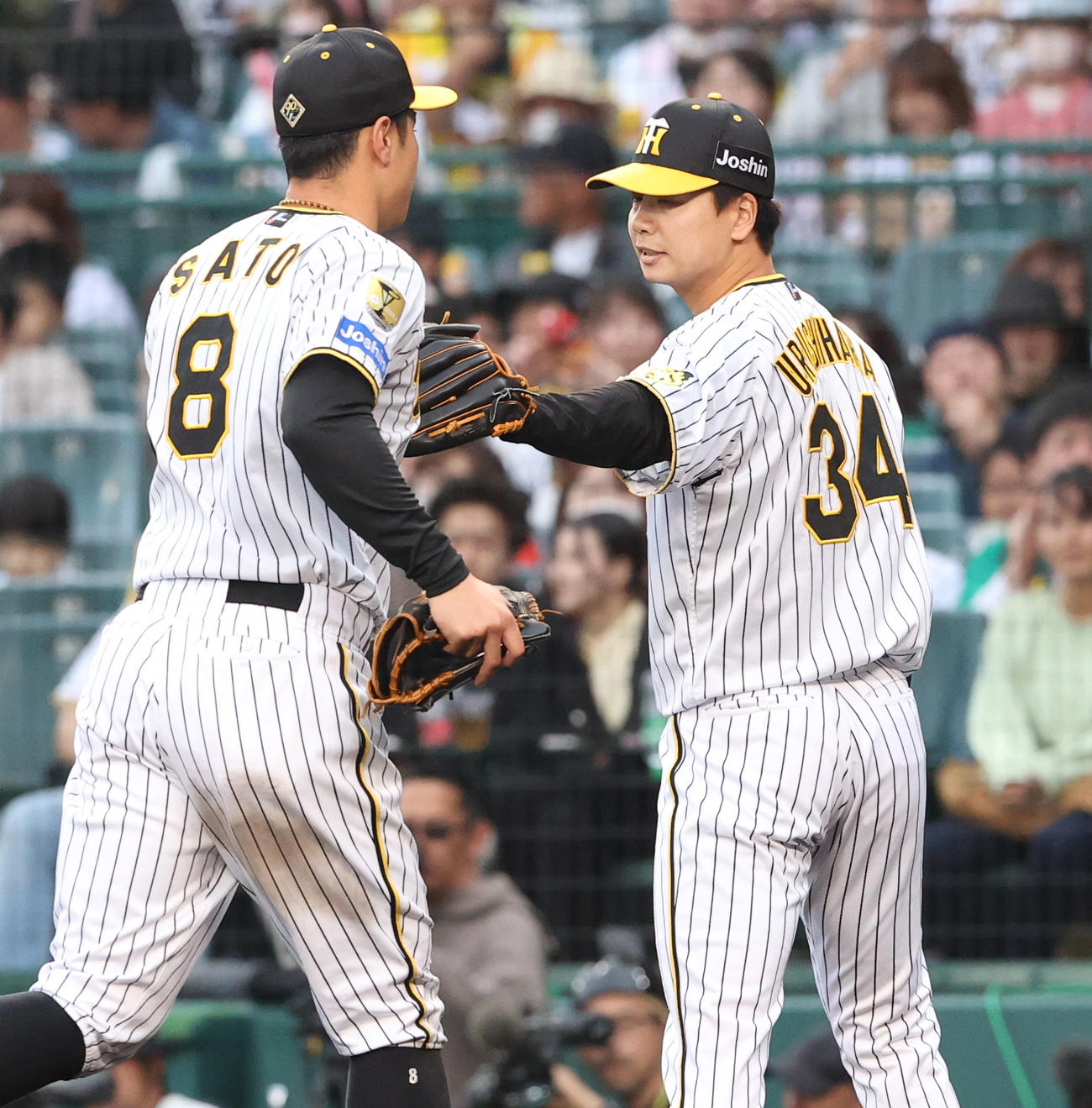 阪神対中日　8回表に登板した漆原（右）は三者凡退に終え佐藤輝とタッチをかわす（撮影・上山淳一）