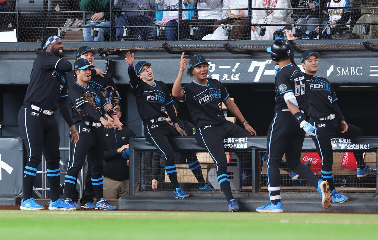 日本ハム対ロッテ　4回裏日本ハム1死一塁、万波（右から2人目）は左越え2点本塁打を放ちナインに出迎えられる（撮影・佐藤翔太）