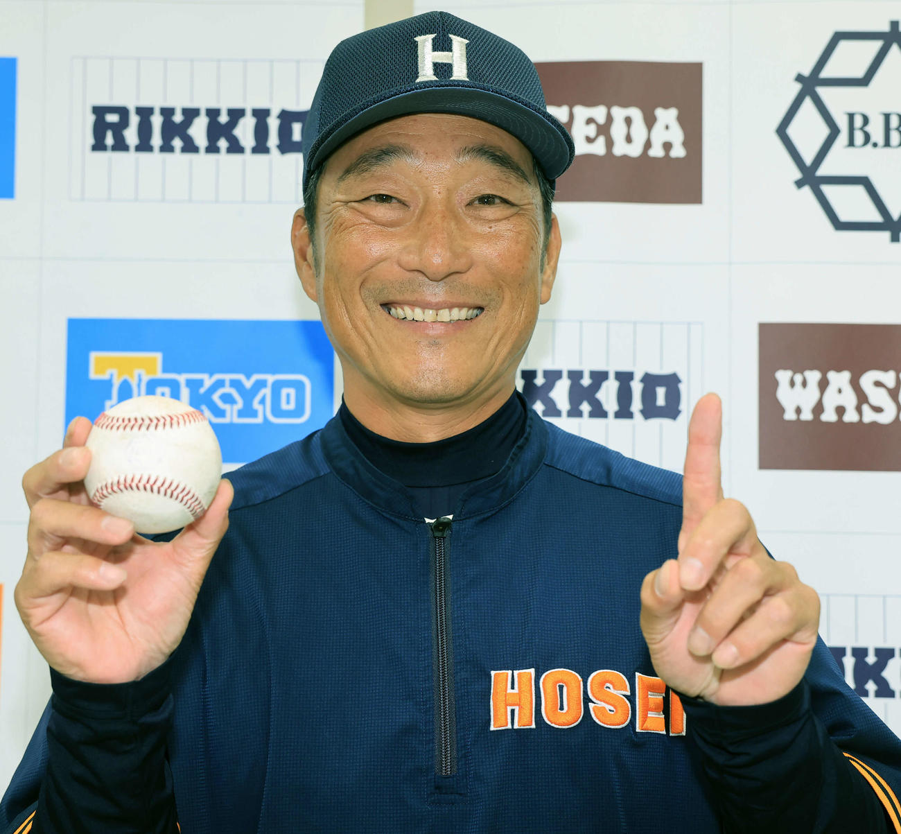 法大対立大　初勝利を挙げた法大・大島監督は、ウイニングボールを手に笑顔で「1」勝のポーズ（撮影・浅見桂子）