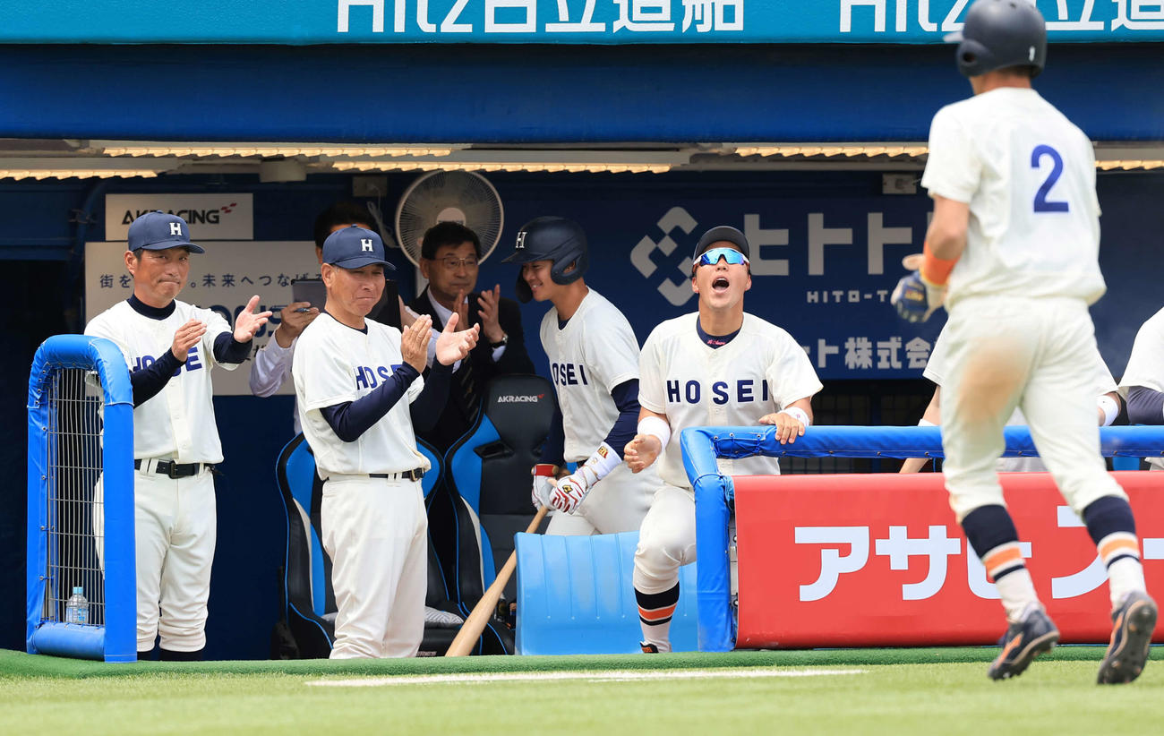 法大対立大　7回表法大2死二塁、松下の左適時打で生還した鈴木照（右）を拍手で迎える大島監督（左）（撮影・浅見桂子）