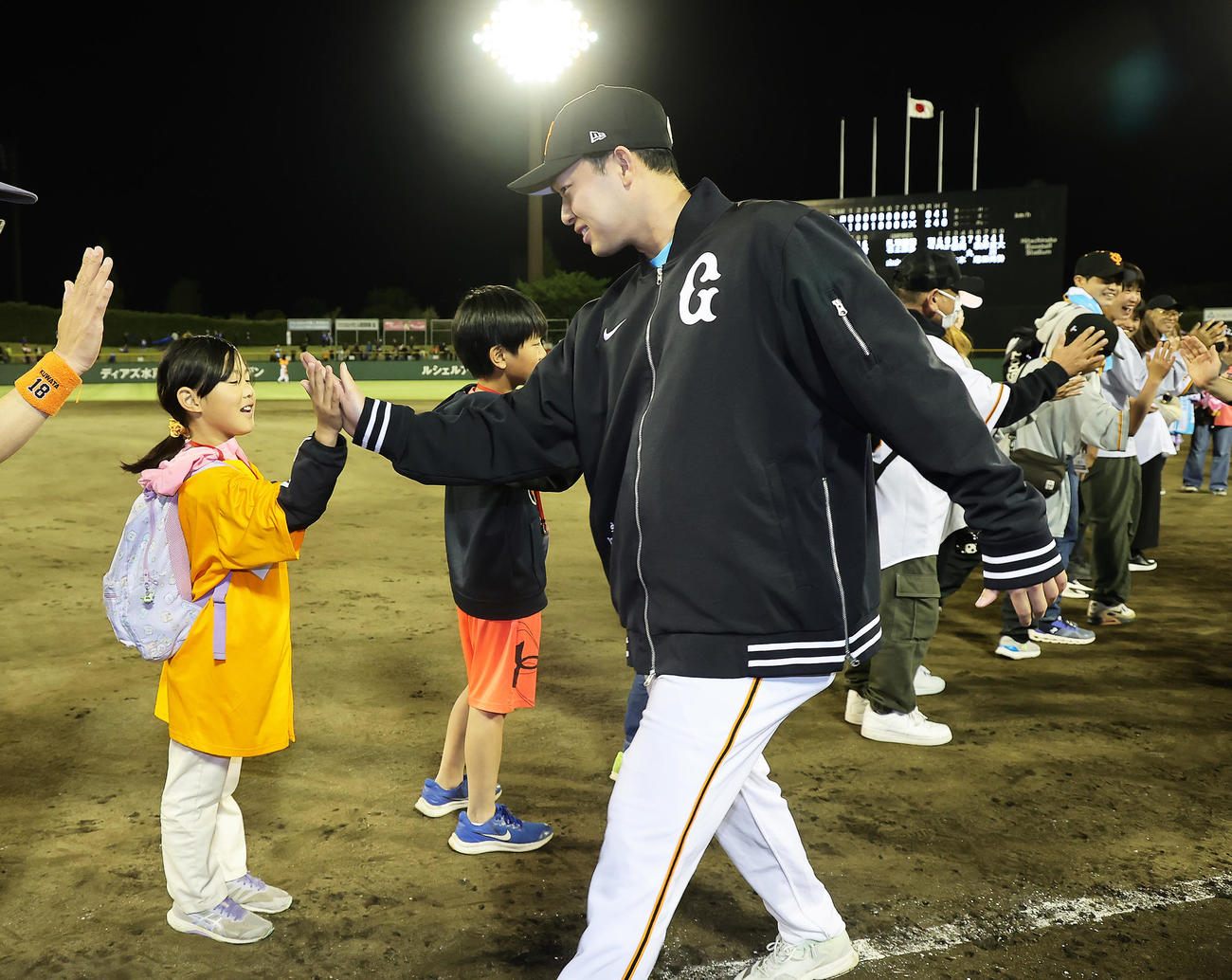 巨人対中日　7回途中無失点で勝利を挙げた巨人山崎伊はファンと笑顔でタッチを交わす（撮影・足立雅史）