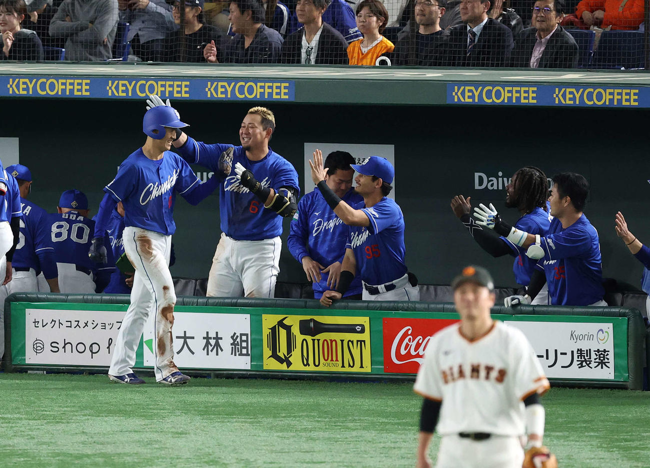 巨人対中日　7回表中日1死三塁、岸田の悪送球で生還しナインに迎えられる尾田（左）。手前は三塁手の坂本（撮影・河野匠）