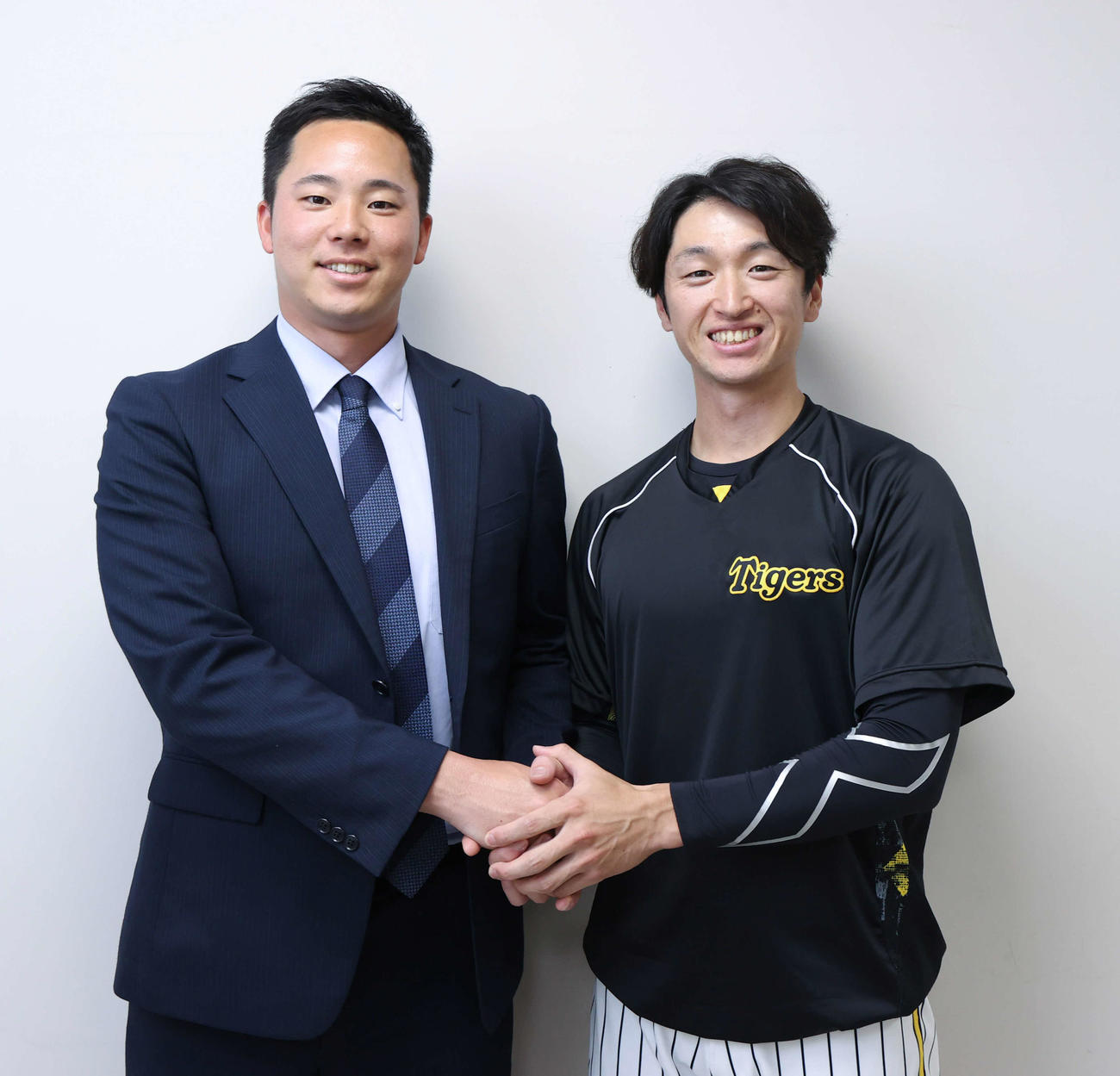 一般社団法人LINK UPを立ち上げ笑顔で握手する阪神近本（右）と石井僚介代表理事（撮影・上山淳一）