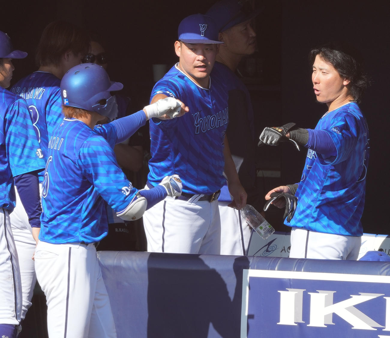日本ハム対DeNA 8回表DeNA1死二、三塁、中犠飛を放った森敬（左手前）を迎える筒香（中央）（撮影・鈴木みどり）