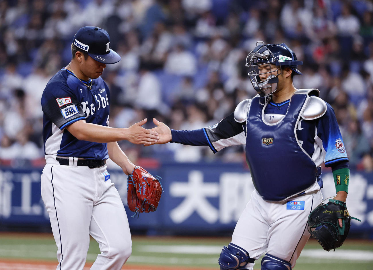 オリックス対西武　5回を終え、タッチを交わす西武ボー（左）と柘植（撮影・藤尾明華）