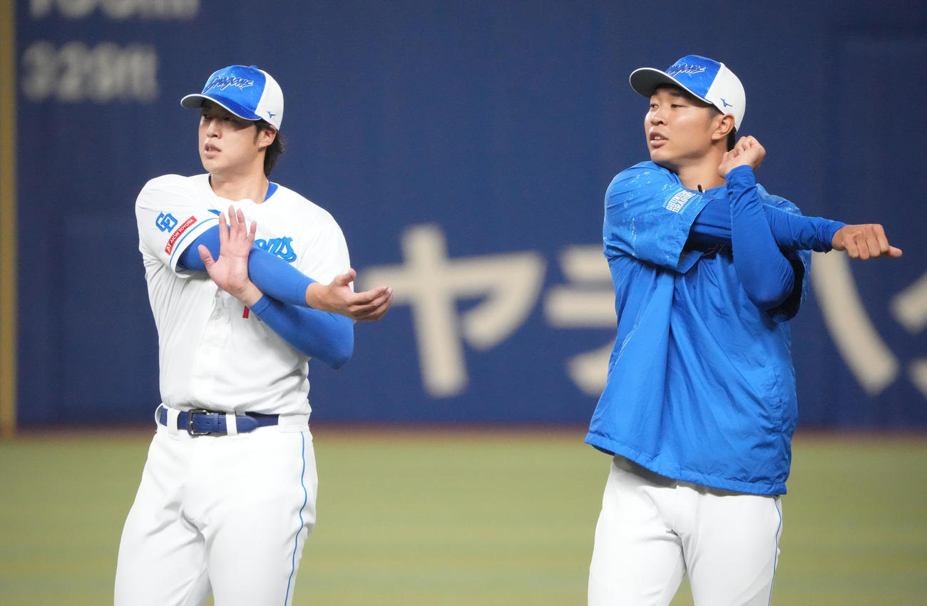 梅津とストレッチをする高橋宏（右）（撮影・森本幸一）