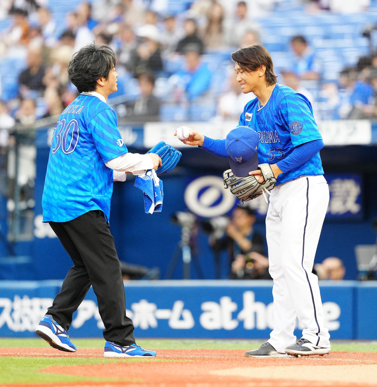 DeNA対巨人　試合前、セレモニアルピッチに臨み、DeNA井上（右）からボールを受け取る「FIELD OF VIEW」ボーカルの浅岡雄也（撮影・江口和貴）