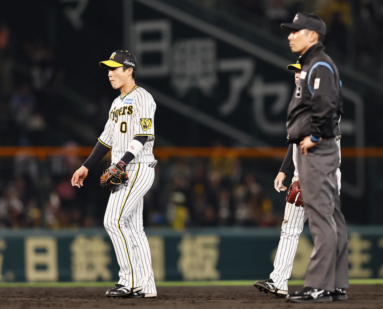 阪神対ヤクルト　4回表ヤクルト無死満塁、西川の中犠飛で送球ミスをし、肩を落とす遊撃手木浪（左）（撮影・藤尾明華）