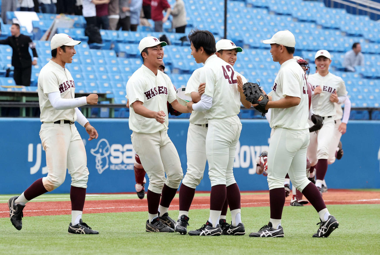 早大対明大　勝利し早大・安田（中央）を笑顔で迎える選手たち（撮影・鈴木正人）